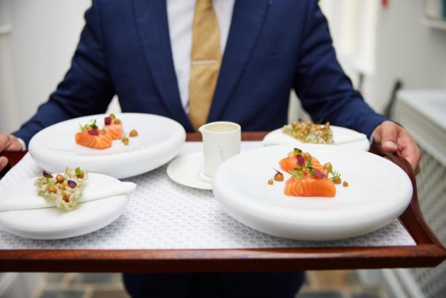 Ein Kellner trägt ein Tablett mit Essen
