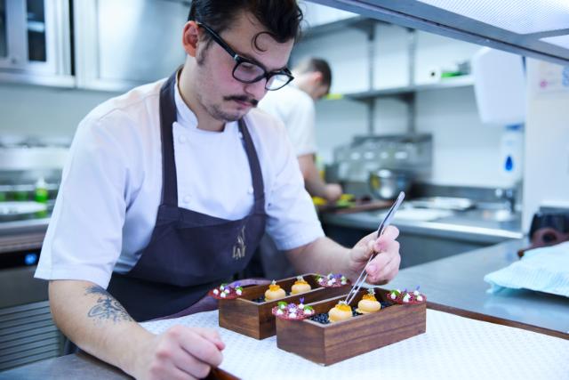 chef preparing dessert with edible flowers